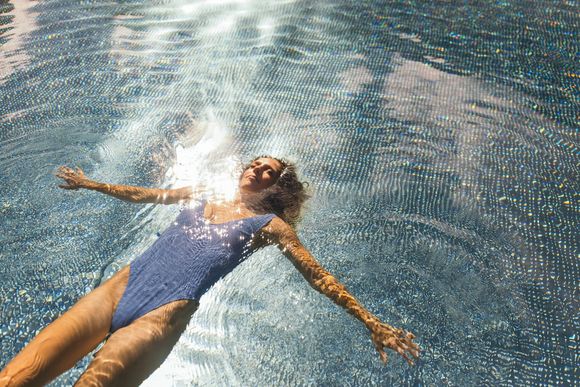 Eine Frau treibt entspannt im Pool des Feelfree Nature Resort