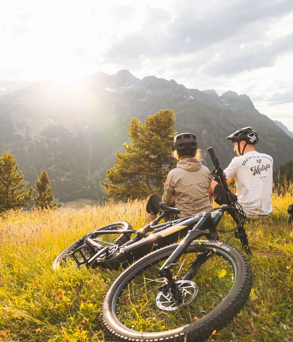 Biker sitzen im Gras hinter ihrem Bike in den Ötztaler Alpen